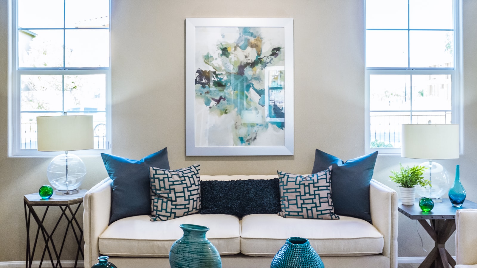 A bright open-plan room with a sofa, dining table, and a tucked-away desk sharing one space