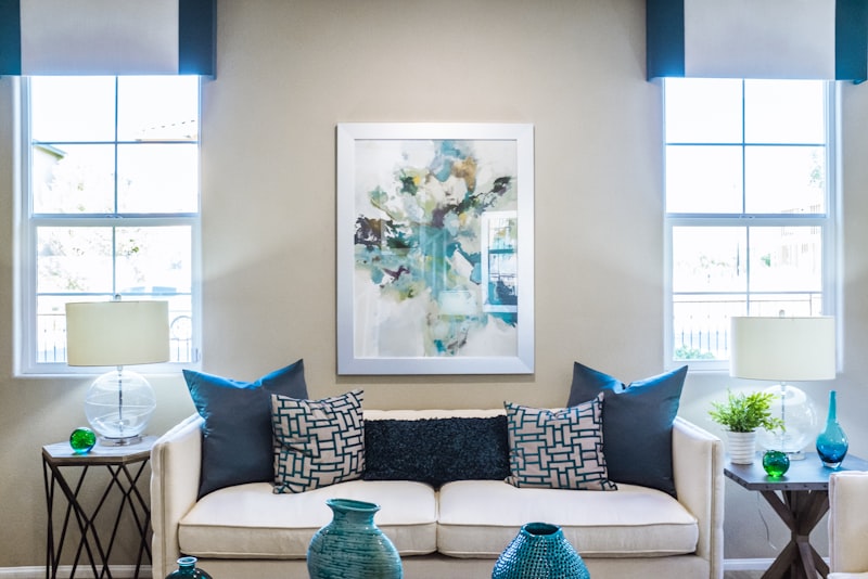 A bright open-plan room with a sofa, dining table, and a tucked-away desk sharing one space