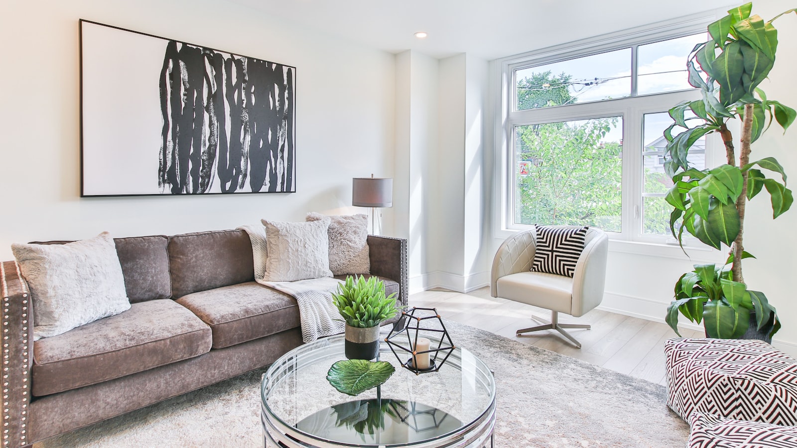 A bright living room with handmade decor, framed art, and a styled shelf in soft daylight