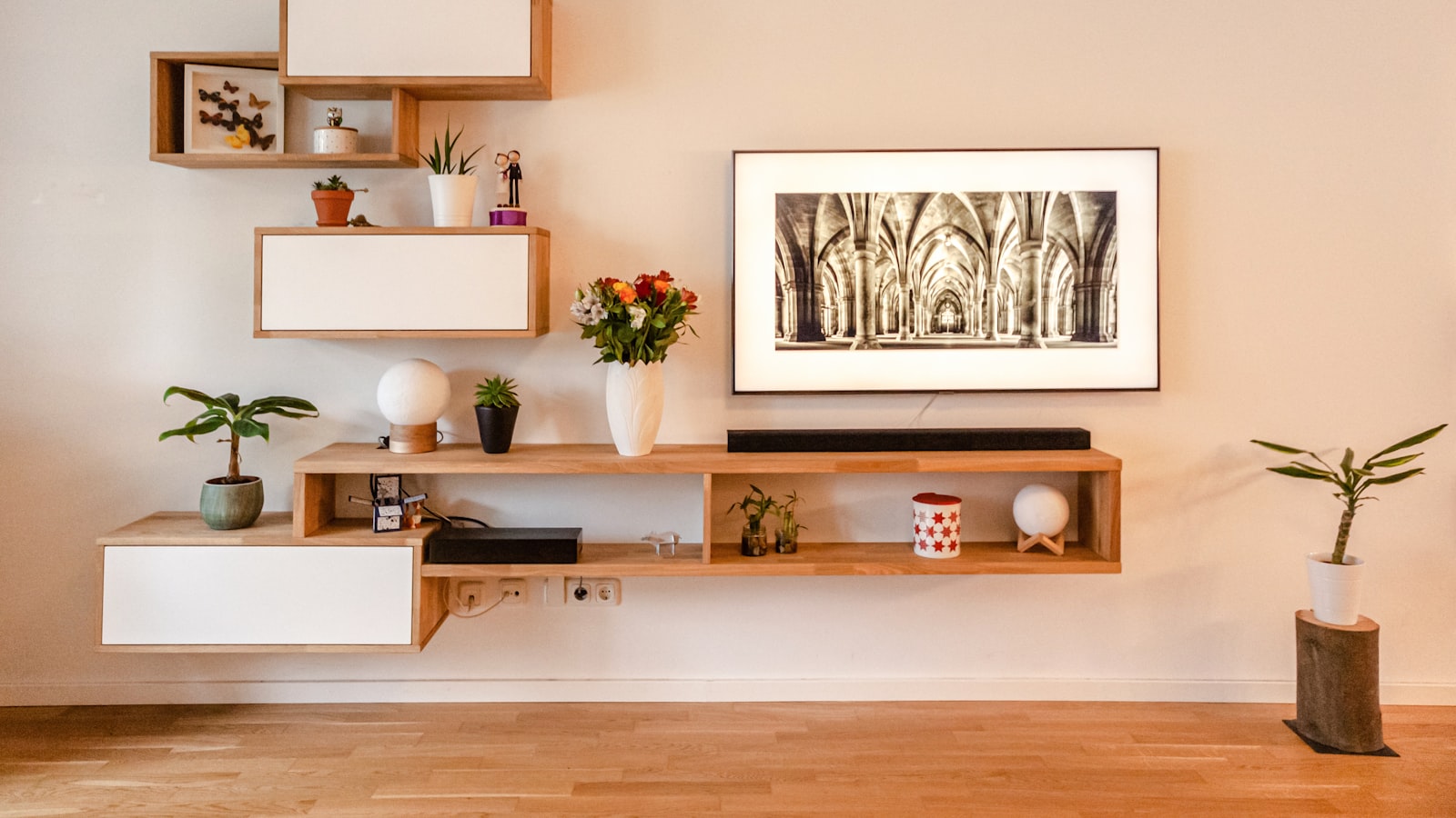 Open shelving styled with stacked books, ceramics, a small plant, and intentional open space.