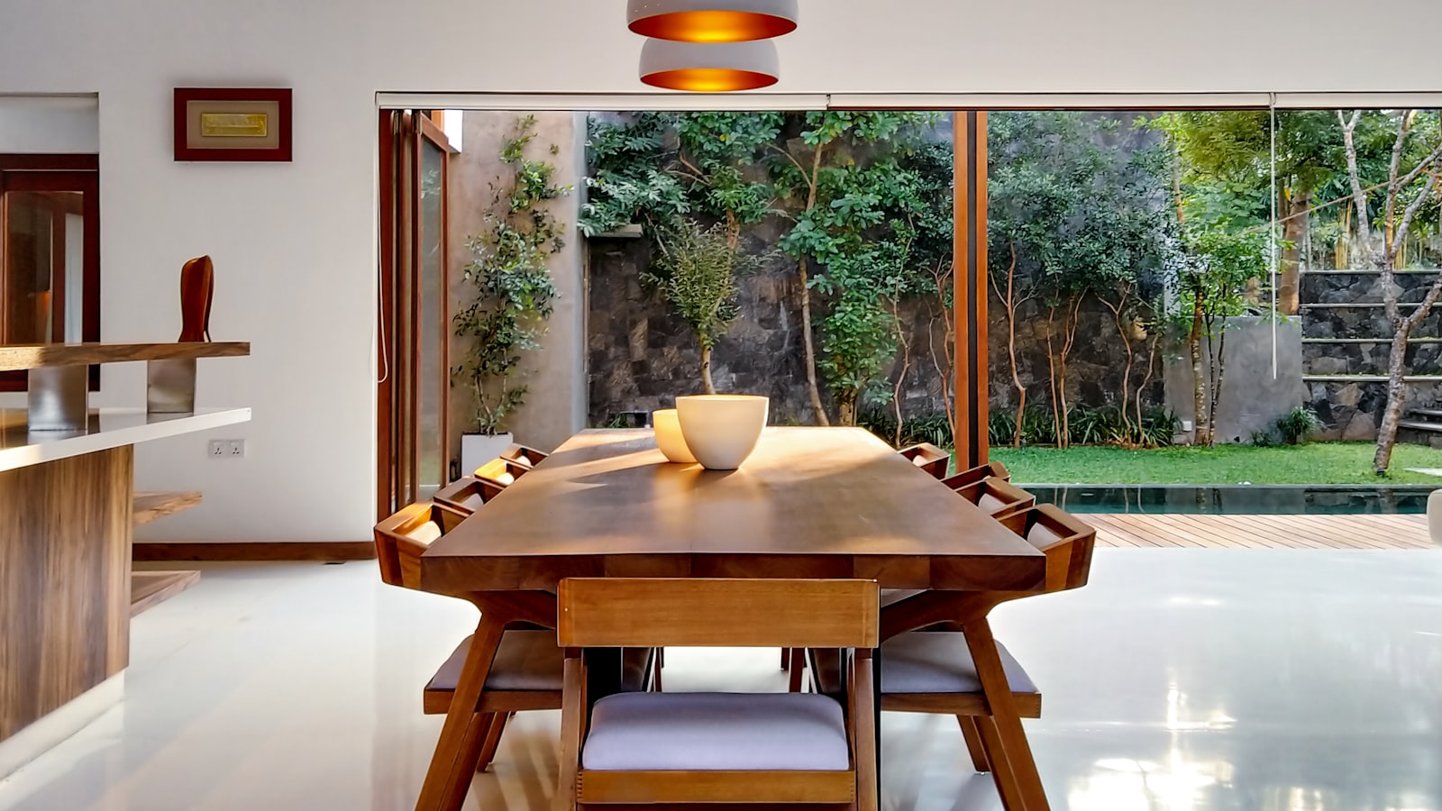 Floor-length linen drapery hanging from a slim metal rod beside a sunlit window in a calm room.