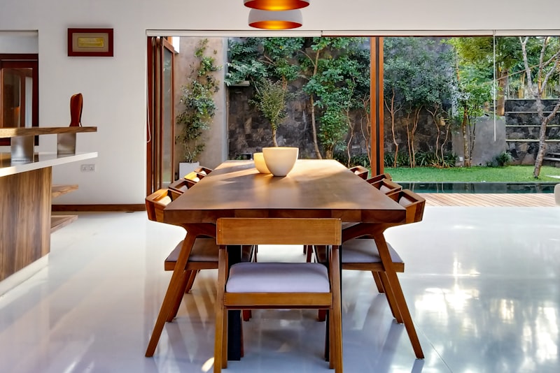 A vibrant living space with a deep blue wall, warm wood furniture, and colorful cushions and art.